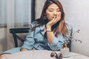 Woman sitting with elbow on table and chin resting in hand