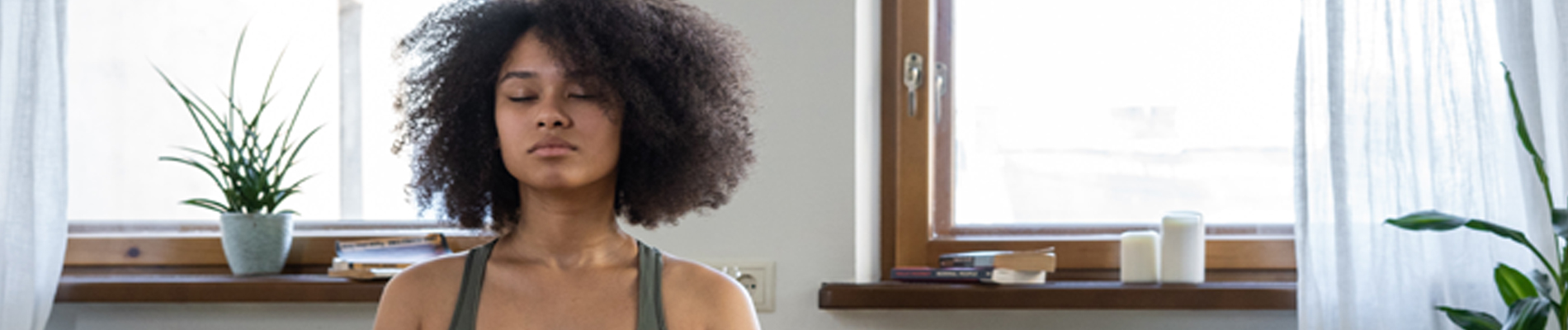 Woman sitting on floor eyes closed and meditating