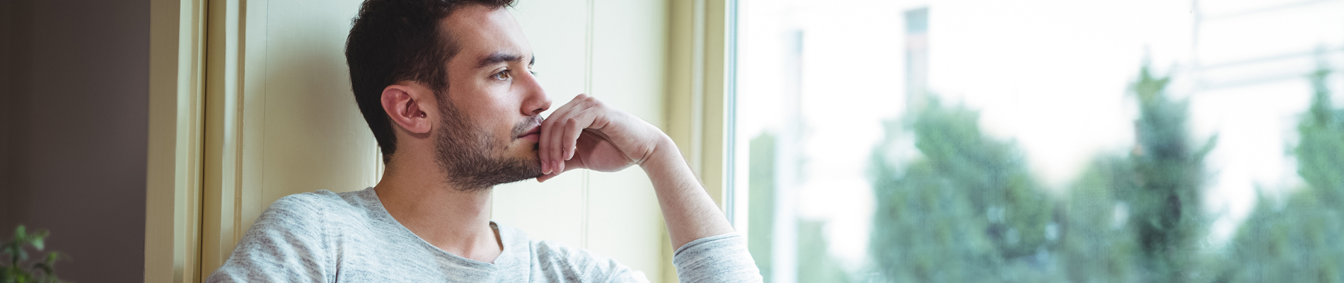 Man sitting in window deep in thought