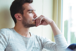Man sitting in window deep in thought