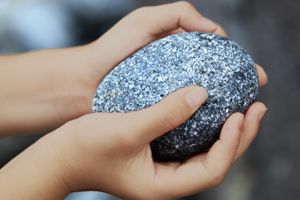 Pair of hands holding a stone