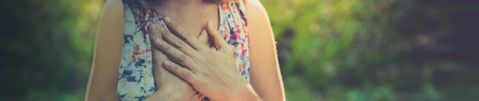 Woman with hands crossed on chest in nature