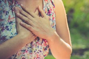 Woman with hands crossed on chest in nature