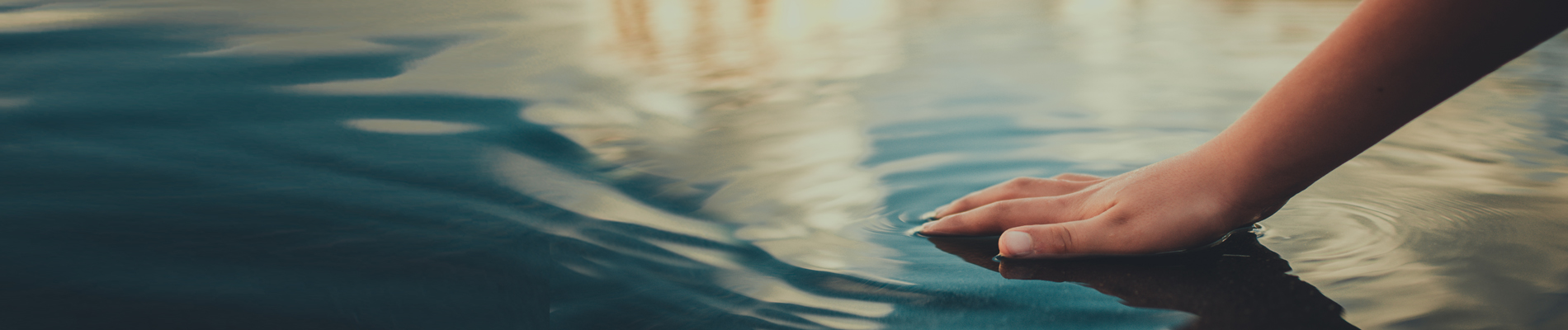 Hand creating ripples in water