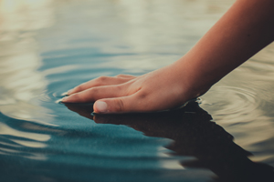 Hand creating ripples in water