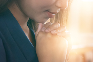 Woman with clasped hand under her chin