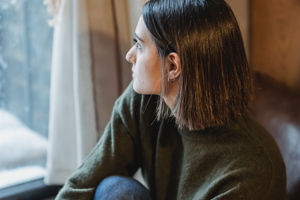 Woman sitting and looking outside in thought