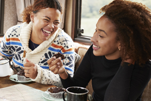 Four people sitting having coffee laughing and talking