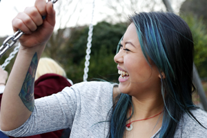 Young woman on a swing laughing