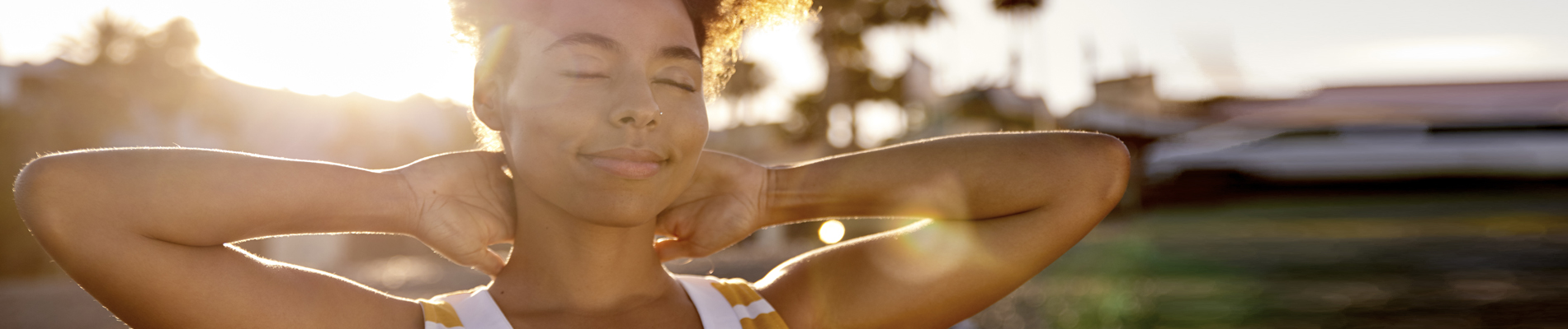 Woman grinning with hands behind her neck
