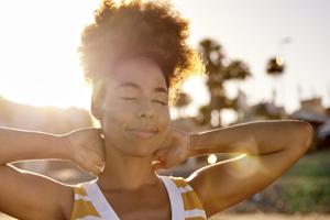 Woman grinning with hands behind her neck