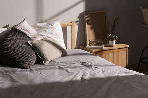 Piled up pillows on a bed in sun light