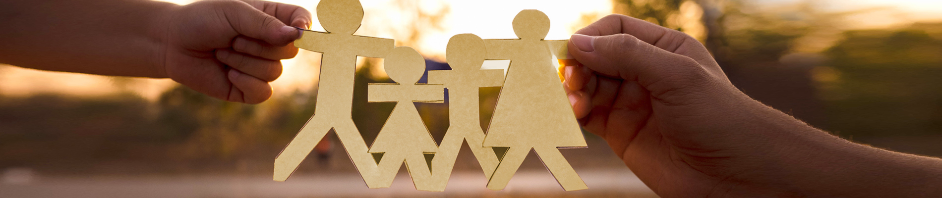 Hands holding a paper cutout of a family, father two kids and mom