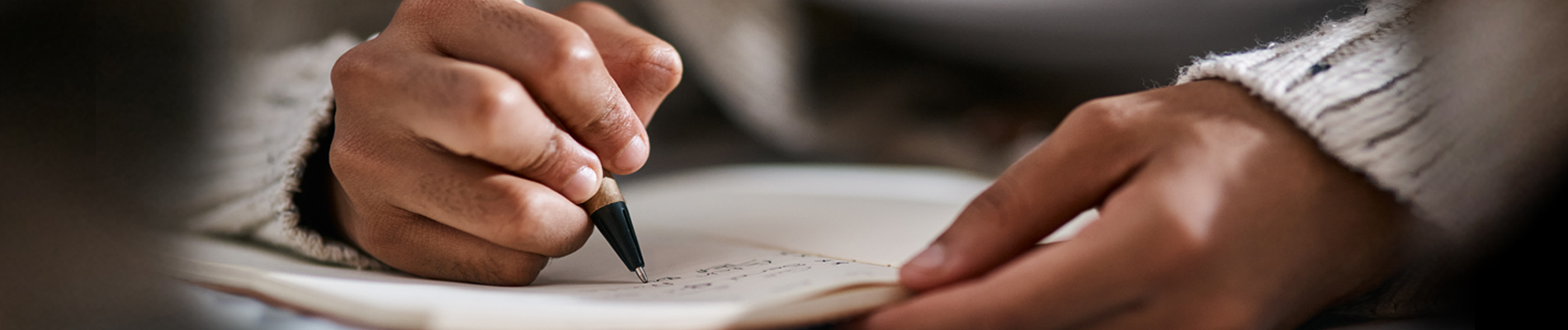 Woman's hands holding and writing in a journal