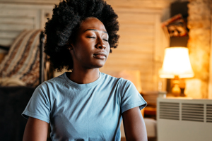 woman with eyes closed in the middle of living room in thought