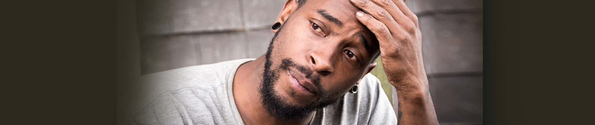 man holding head in one hand in thought