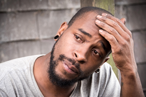man holding head in one hand in thought