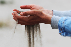 hands with sand running through them