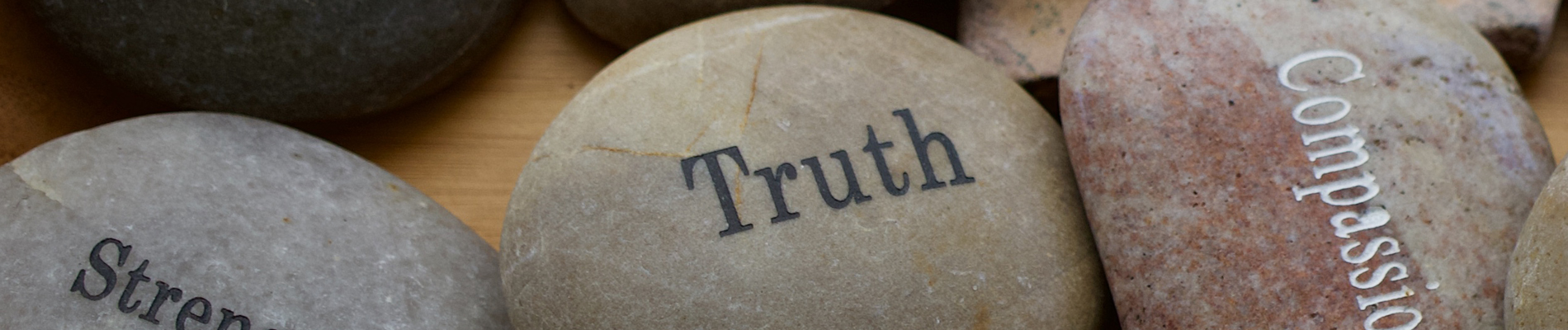 Three stones with the words, Strength, Truth and Compassion