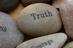 Three stones with the words, Strength, Truth and Compassion