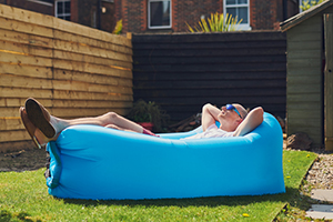 Man laying back in a one person pool enjoying the moment in the sun