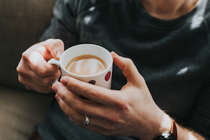 Hands holding a full cup of coffee