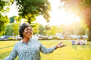 A woman laughing in an open area within a campground