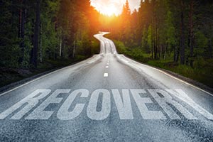 A road with the wording RECOVERY painted across it