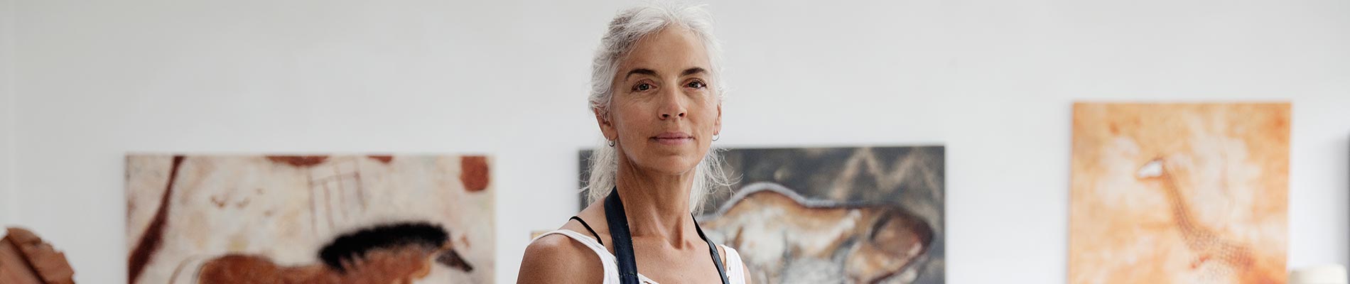 A woman standing in a room with paintings on the wall