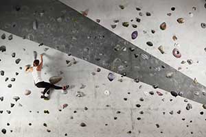 Woman climbing a rock wall without safety rope
