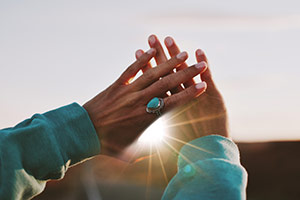 Woman hands up crossed blocking the sun