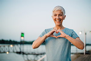 Woman smiling with hand forming a heart