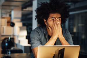Man at computer contemplating