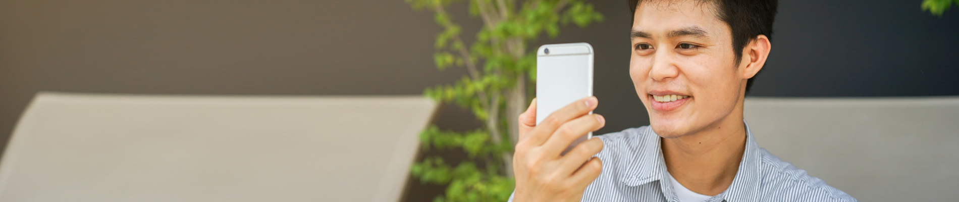 Man looking at his cell phone grinning