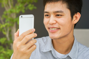 Man looking at his cell phone grinning