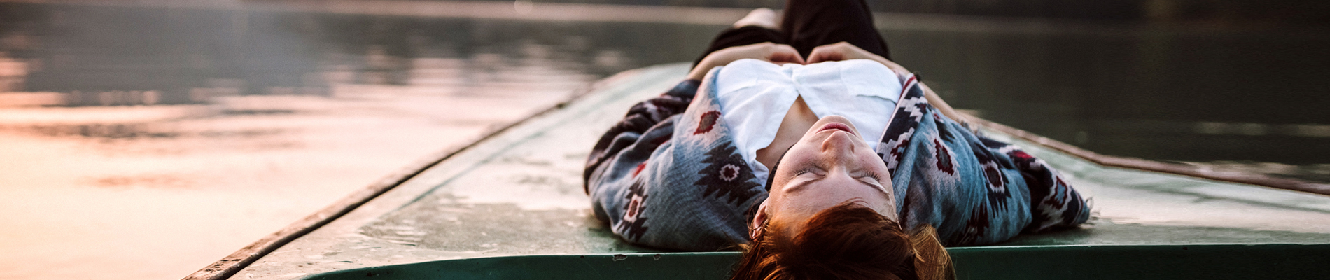 Woman lying on a platform by a lake