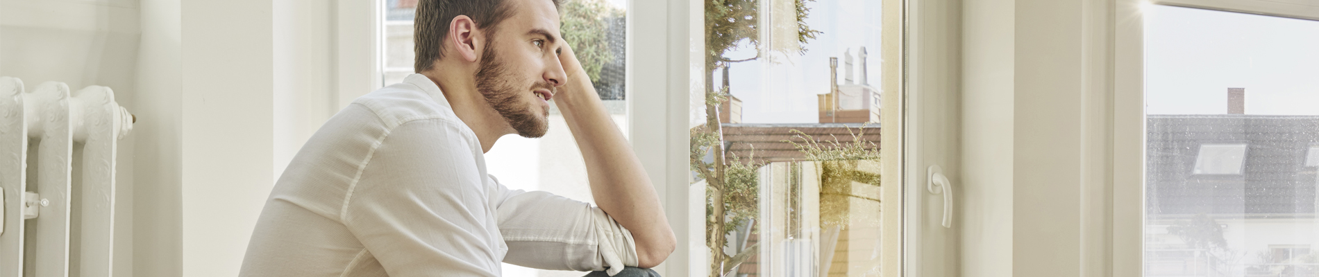 A young man sitting looking out the front window