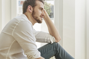 A young man sitting looking out the front window