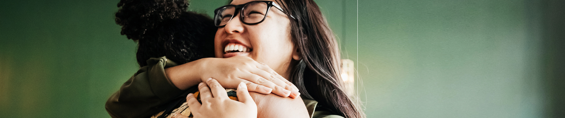 two women in a warm embrace smiling
