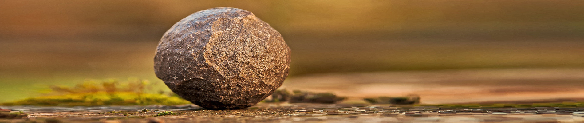 Medium size rock sitting alone on a flat rocky surface