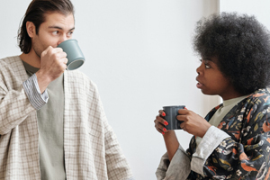 A woman and man with coffee having a discussion