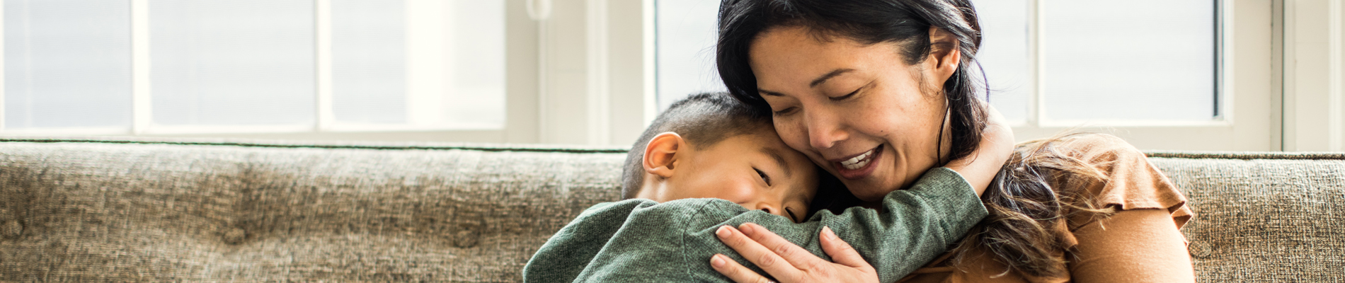 Mother and son hugging on a couch