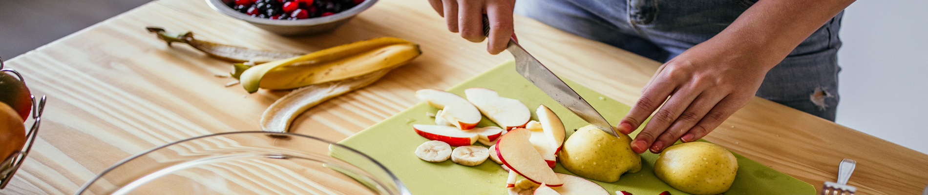fresh apples, bananas, cherries and pears being cut up