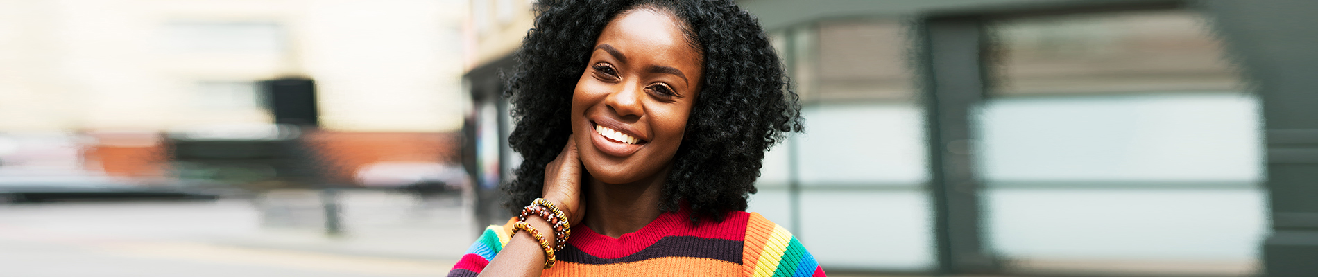 Woman standing in a colorful sweater grinning
