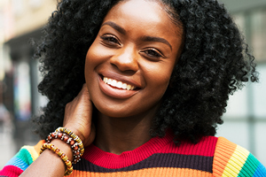 Woman standing in a colorful sweater grinning