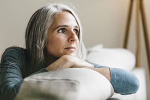 Woman gazing out window on couch