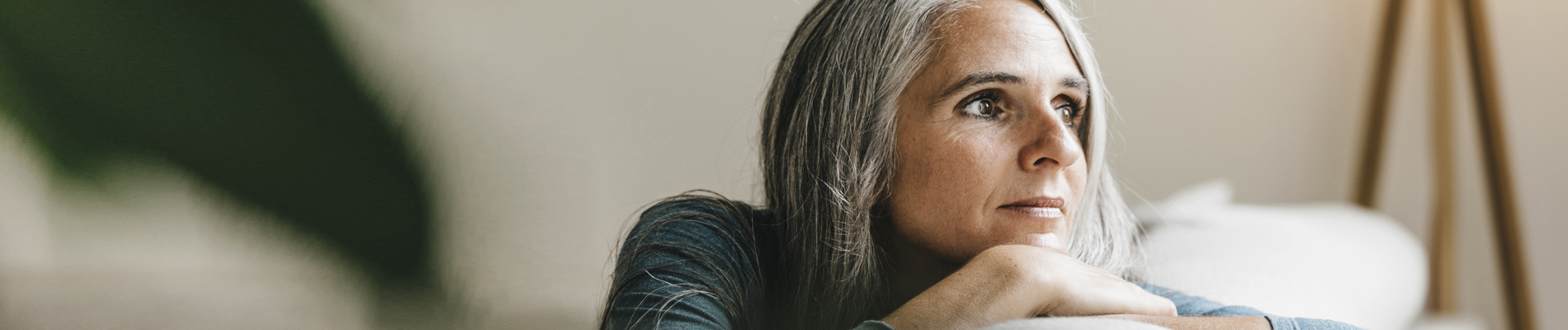 Woman gazing out window on couch