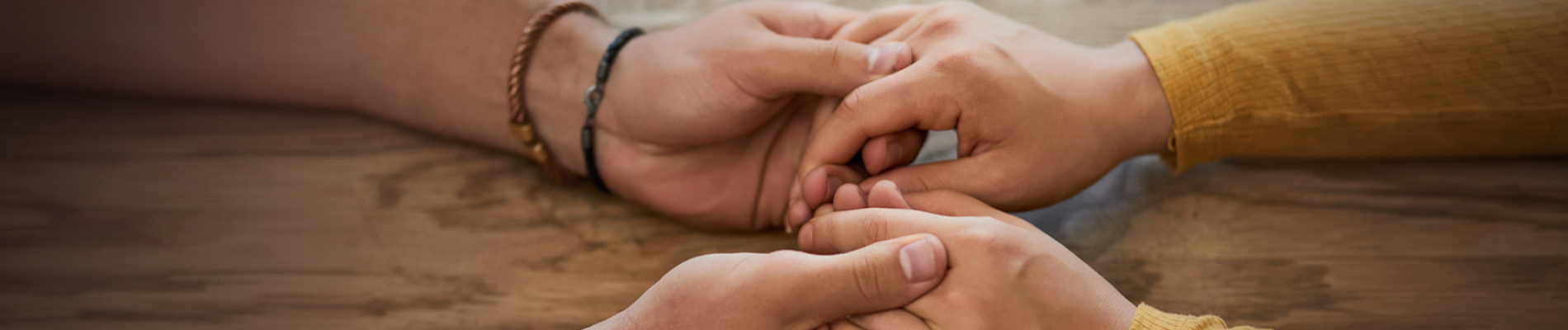 Two out stretched arms with holding hands