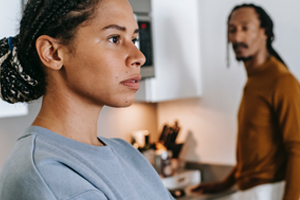 A couple standing apart in the kitchen with lost gaze on faces