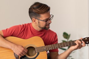 A young man playing a guitar